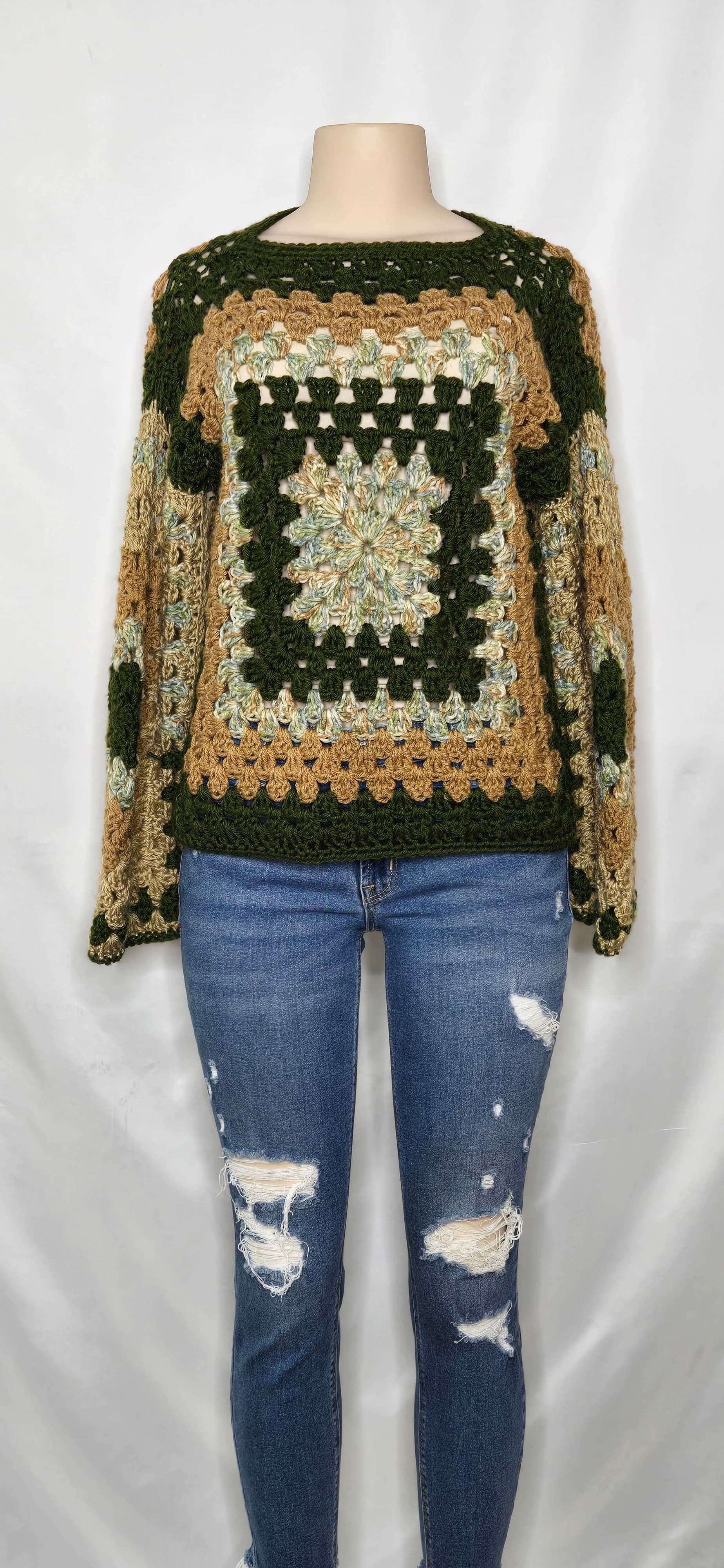 Green crocheted cardigan with multicolor detail on a mannequin